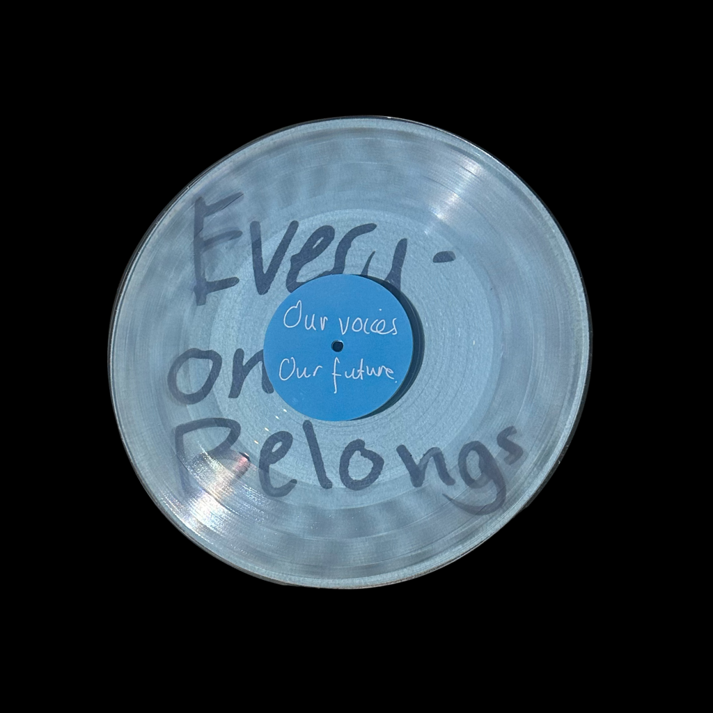 A photograph of Side B of the On the Record vinyl. Words on the vinyl read "Everyone belongs. Our voices. Our future."